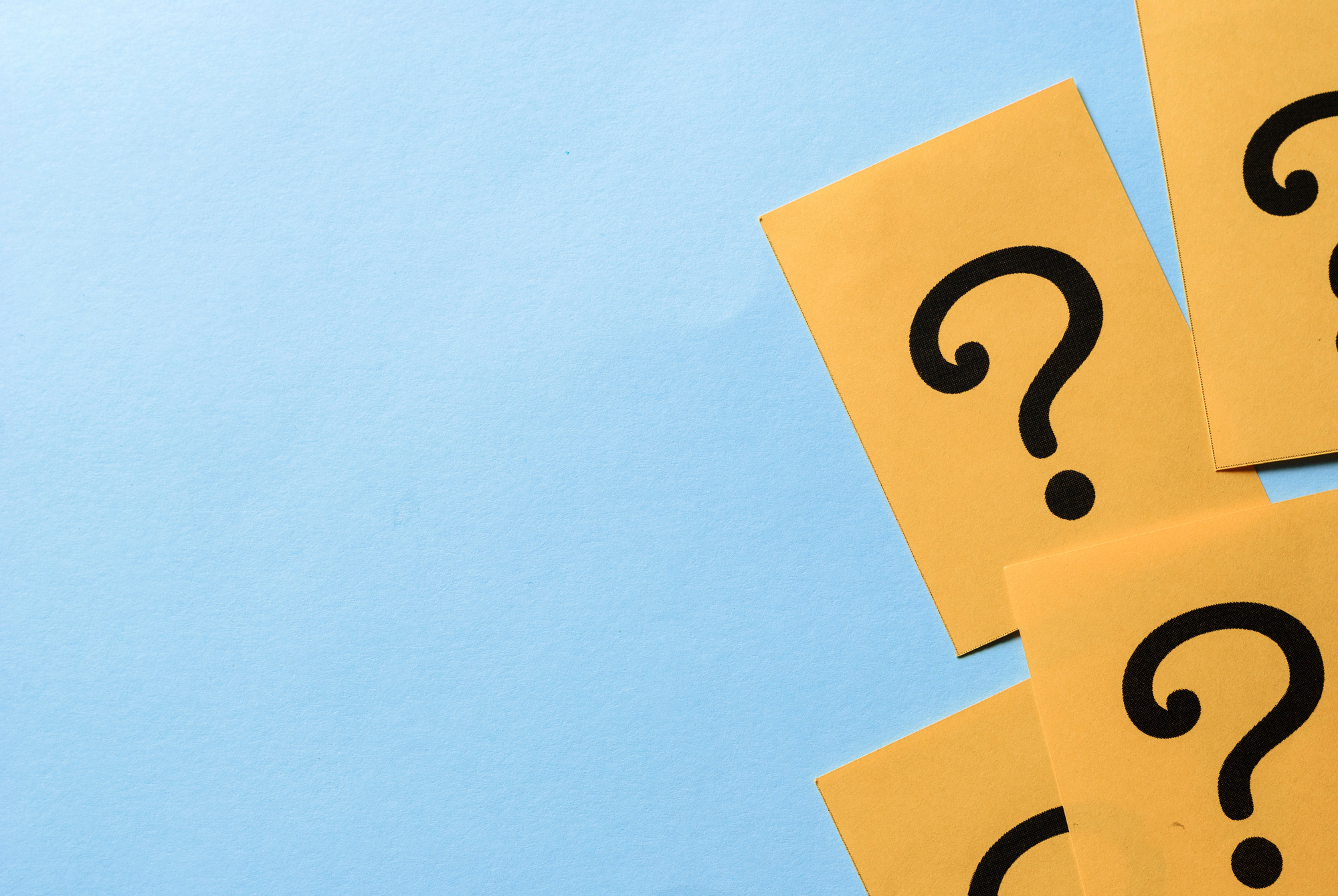 Vier Fragezeichen vor einem blauen Hintergrund